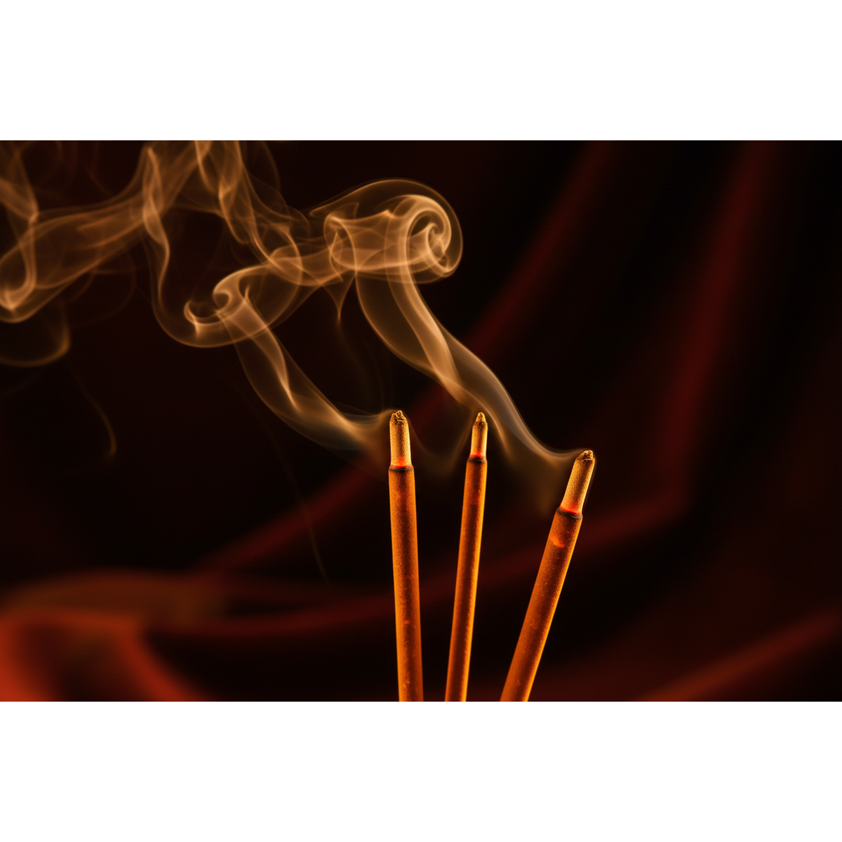 Three incense sticks with smoke against a dark background Sun's Eye Scentsium