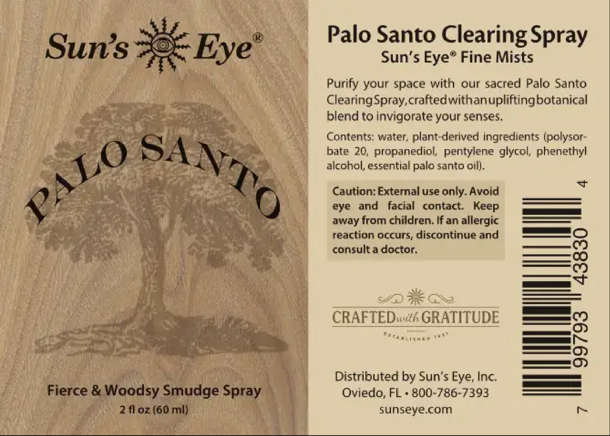 The back of a Sun's Eye Palo Santo Clearing Spray bottle, showing the product name, ingredients, warnings, and barcode on a light beige background with a wood-grain texture. Sun's Eye Scentsium