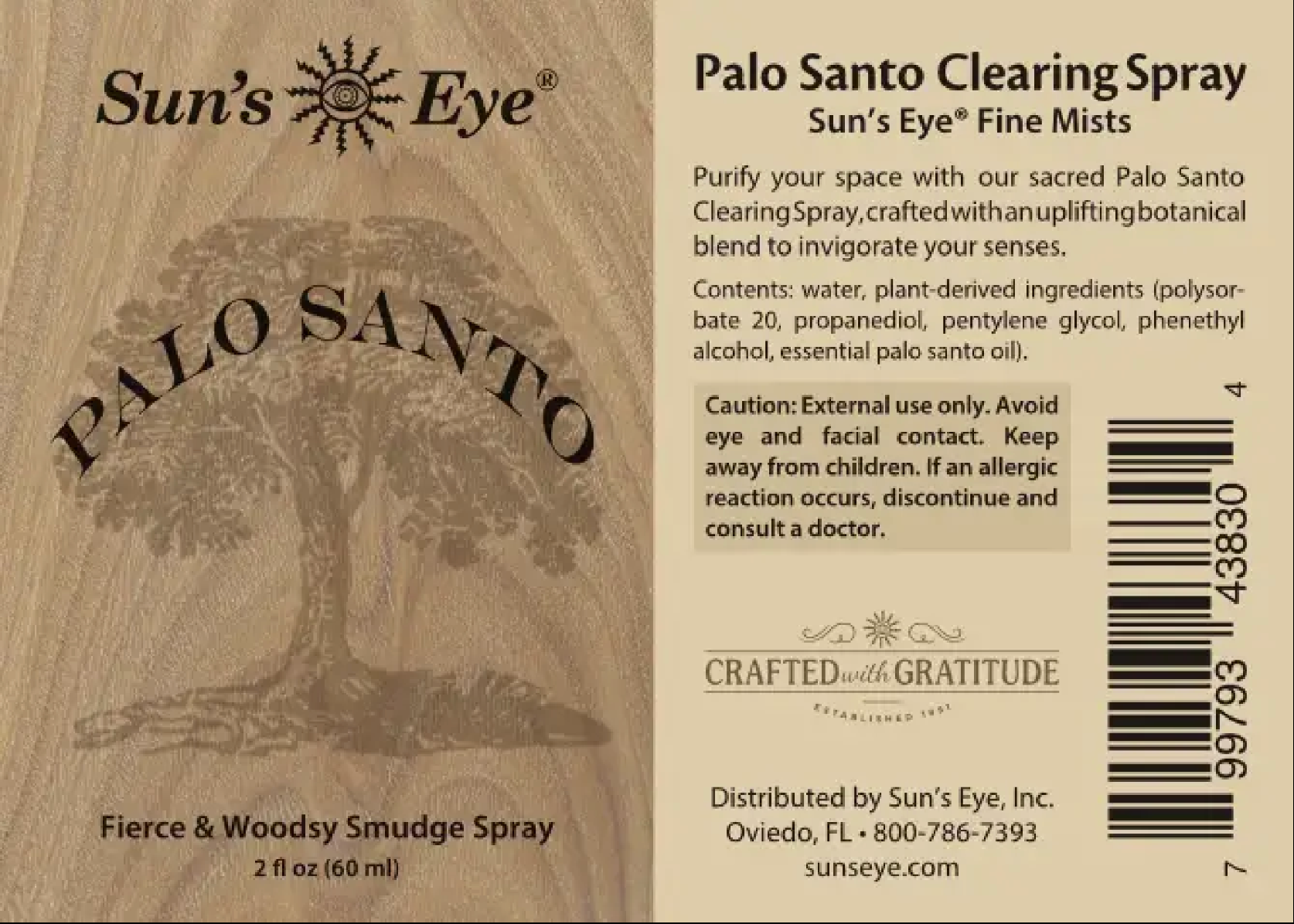 The back of a Sun's Eye Palo Santo Clearing Spray bottle, showing the product name, ingredients, warnings, and barcode on a light beige background with a wood-grain texture.
