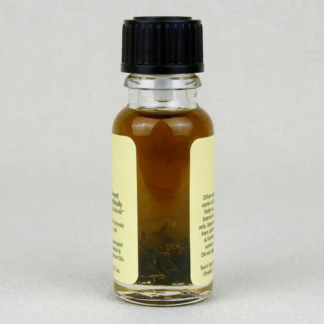 Small glass bottle of sweet patchouly oil with a black cap and yellow label on a light gray background Sun's Eye Scentsium Sun's Eye Scentsium