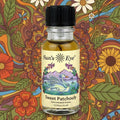 Bottle of Sun's Eye Sweet Patchouly with a colorful floral and nature-themed background