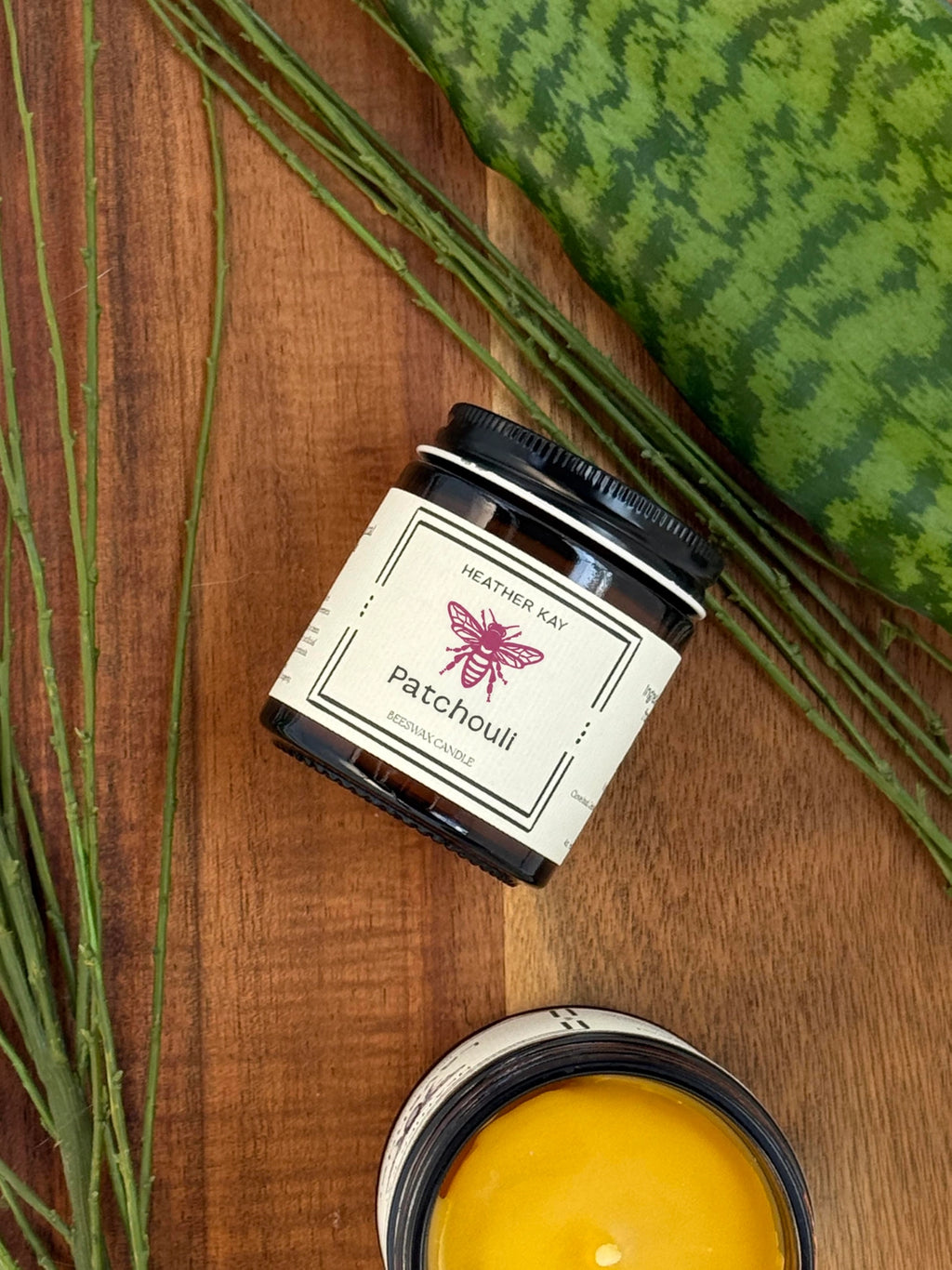 A jar of Heathly Gel Patchouli heat therapy gel, styled on a wooden surface with green leaves, a watermelon slice, and a yellow gel sample container.