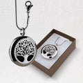 Silver tree-shaped locket necklace with a matching pendant in a box on a light gray background