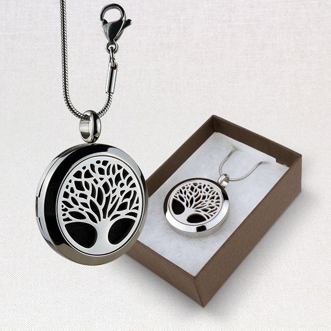 Silver tree-shaped locket necklace with a matching pendant in a box on a light gray background