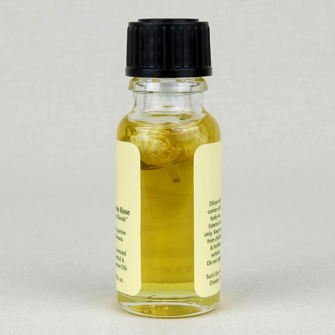 Small glass bottle with a black cap and yellow liquid on a light gray background