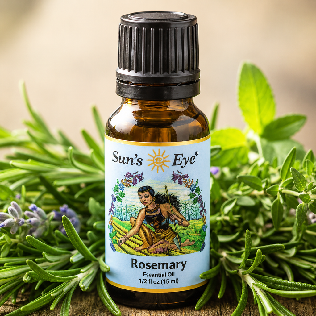 Bottle of Sun's Eye Rosemary Essential Oil surrounded by rosemary leaves on a wooden surface.