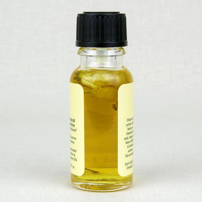 Small glass bottle with tropical Jasmine and a black cap on a white background